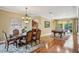 Open dining room with hardwood floors connecting the kitchen and a recreation room with a pool table at 3637 Ballastone Dr, Land O Lakes, FL 34638