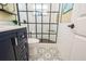 Elegant bathroom with unique patterned floors, a black framed glass shower and navy blue vanity at 3715 98Th N Ave # 3, Pinellas Park, FL 33782