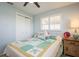 Bright bedroom featuring a double bed with a patterned quilt and white shuttered window at 3715 98Th N Ave # 3, Pinellas Park, FL 33782