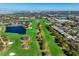 An aerial view captures the golf course and pond of the community with condo buildings in the foreground at 39 Pelican Pl, Belleair, FL 33756
