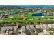 An aerial view shows the community's golf course, lake, and condo complex with lush green landscaping at 39 Pelican Pl, Belleair, FL 33756