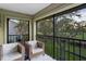 Screened-in lanai with comfortable seating overlooking golf course and mature trees at 39 Pelican Pl, Belleair, FL 33756