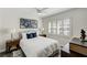 Bright bedroom featuring a comfortable bed, stylish decor, and ample natural light from the shuttered windows at 39 Pelican Pl, Belleair, FL 33756
