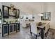 Dining area with modern light fixture, bar area, and a view of the adjacent updated kitchen at 39 Pelican Pl, Belleair, FL 33756