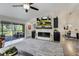 Living room featuring a stone fireplace, a large screen television, and access to the screened-in outdoor balcony at 39 Pelican Pl, Belleair, FL 33756