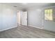 This is a well-lit room featuring gray wood floors, with paneled walls, and a glass-paneled door at 39051 Manor Dr, Zephyrhills, FL 33542