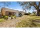 Spacious backyard featuring a sun room addition, neutral siding, white trim, and green foliage at 4069 102Nd N Pl, Clearwater, FL 33762