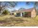 View of spacious backyard with green foliage, neutral siding, white trim, and sun room addition at 4069 102Nd N Pl, Clearwater, FL 33762