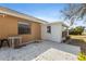 Back exterior of house with sun room addition on a cement patio with white door, windows, and neutral siding at 4069 102Nd N Pl, Clearwater, FL 33762
