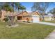 Well-maintained home featuring a lush green lawn, mature trees, and attached two-car garage at 4069 102Nd N Pl, Clearwater, FL 33762