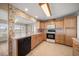 Traditional kitchen with wood cabinets, black appliances, and floral wallpaper at 4582 Fox Lake Ct, Clearwater, FL 33762