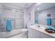 Bright bathroom with a large mirror, tub and shower combination, with a matching blue towel accent at 4830 Osprey S Dr # 305, St Petersburg, FL 33711