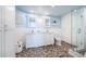 Light and airy bathroom with double vanity, pebble flooring, and glass enclosed shower at 4830 Osprey S Dr # 305, St Petersburg, FL 33711