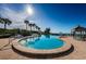 An expansive community pool featuring crystal-clear blue water and palm trees under a clear sky at 4830 Osprey S Dr # 305, St Petersburg, FL 33711