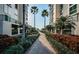 Brick-paved walkway with palm trees and manicured tropical landscaping between condo buildings at 4830 Osprey S Dr # 305, St Petersburg, FL 33711