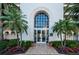 Beautiful building entrance framed by tropical landscaping, potted flowers, and an arched doorway at 4830 Osprey S Dr # 305, St Petersburg, FL 33711