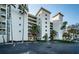 Exterior shot of the condo featuring a circular drive, tropical landscaping, and ample parking at 4830 Osprey S Dr # 305, St Petersburg, FL 33711