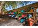 Outdoor storage rack filled with colorful kayaks ready for water adventures, shaded by a tree at 4830 Osprey S Dr # 305, St Petersburg, FL 33711