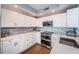 Modern kitchen with white cabinets, stainless appliances, and tile backsplash at 4830 Osprey S Dr # 305, St Petersburg, FL 33711