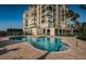 Beautiful in-ground pool with brick paver surround in front of condo complex under clear blue skies at 4830 Osprey S Dr # 305, St Petersburg, FL 33711