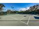 Exterior view of a community tennis court featuring mature trees and manicured landscape at 4830 Osprey S Dr # 305, St Petersburg, FL 33711