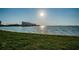 Scenic waterfront view with lush green grass and calm blue water reflecting the sunlight at 4830 Osprey S Dr # 305, St Petersburg, FL 33711