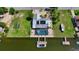 Aerial view of a waterfront home features a private dock, screened-in pool, and lush landscaping at 5024 Cedarbrook Ln, Hernando Beach, FL 34607
