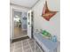 Home entryway featuring an accent table with coastal decor, an open doorway, and tiled flooring at 5024 Cedarbrook Ln, Hernando Beach, FL 34607