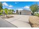 Well-maintained single-story home with a wide driveway, lush landscaping, and a two-car garage at 5024 Cedarbrook Ln, Hernando Beach, FL 34607
