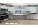 Spacious kitchen with gray cabinets, white upper cabinets, stainless steel appliances, and water views at 5024 Cedarbrook Ln, Hernando Beach, FL 34607