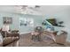 Bright living room with comfortable seating, TV, ceiling fan, and coastal-themed decor at 5024 Cedarbrook Ln, Hernando Beach, FL 34607