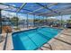 Relaxing in-ground pool with clear water, screened-in enclosure, and a waterfront view at 5024 Cedarbrook Ln, Hernando Beach, FL 34607