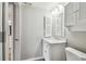 Bright bathroom featuring a white vanity with marble countertop and cabinet with louvered door at 5822 Silver Moon Ave, Tampa, FL 33625