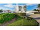 Modern white apartment building featuring multiple balconies, a well-kept lawn, and a driveway at 6210 Sun Blvd # 408, St Petersburg, FL 33715