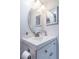 Bright bathroom with white vanity and modern fixtures and round mirror at 6210 Sun Blvd # 408, St Petersburg, FL 33715