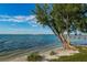 Beautiful waterfront view featuring clear water, sandy beach, and a wooden dock extending into the horizon at 6210 Sun Blvd # 408, St Petersburg, FL 33715