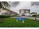 Exterior view of condo buildings with well-manicured lawns, parking, and clear signage at 6210 Sun Blvd # 408, St Petersburg, FL 33715