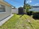 View of backyard with lawn and shed set amongst trees, and white fence in the background at 6310 57Th N Ave, St Petersburg, FL 33709