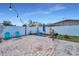 Large brick patio backyard with a white fence, grill, and blue Adirondack chairs at 6310 57Th N Ave, St Petersburg, FL 33709