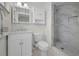 Bright bathroom features modern vanity, toilet, and walk-in shower with gray marble-look tile at 6310 57Th N Ave, St Petersburg, FL 33709