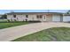 Charming single-story home with an attached garage, driveway, and manicured front lawn at 6310 57Th N Ave, St Petersburg, FL 33709