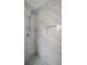 Walk in shower with marble-like tile from floor to ceiling, decorative tile accents, and modern shower head at 6310 57Th N Ave, St Petersburg, FL 33709