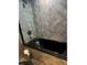 Bathroom with black tub, tiled walls, and glass shower enclosure at 6425 Shoreline Dr # 10506, St Petersburg, FL 33708
