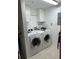 Bright laundry room featuring a washer, dryer, white cabinets, and tile floors at 6425 Shoreline Dr # 10506, St Petersburg, FL 33708