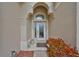 Front door with decorative glass and an arched transom window, surrounded by stucco walls and landscaping at 827 Seminole Sky Dr, Ruskin, FL 33570