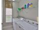Bright laundry room with front load washer and dryer, shelf storage and window at 827 Seminole Sky Dr, Ruskin, FL 33570