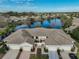 Scenic aerial view of townhomes overlooking a serene lake with mature trees at 838 Tremont Greens Ln, Sun City Center, FL 33573