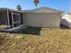 A grassy backyard with a screened-in back porch attached to the home at 8615 Newton Dr, Port Richey, FL 34668