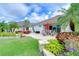 A beautifully landscaped backyard featuring a paver patio with outdoor furniture and lush tropical foliage at 9511 Laurel Ledge Dr, Riverview, FL 33569