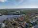 Aerial view of a waterfront community with lush greenery, a body of water, and residential homes at 992 San Carlos Ne Ct, St Petersburg, FL 33702